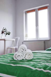 a green and white bed with towels on top of it at Pokoje Łebska 24 in Łeba