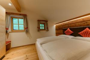 1 Schlafzimmer mit 2 Betten und 2 Fenstern in der Unterkunft Mooserhof in Sand in Taufers