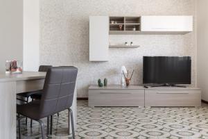 un salon avec une télévision, une table et des chaises dans l'établissement A Kasa di Deia', à Gaète