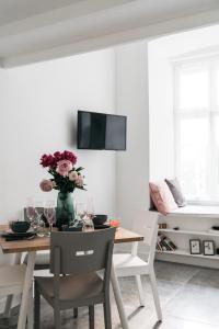 ein Esszimmer mit einem Tisch und einer Vase aus Blumen in der Unterkunft Cosy Place by LoftAffair in Krakau