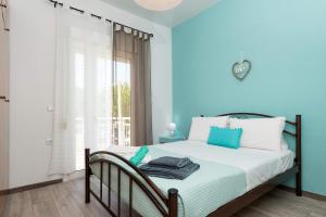 a bedroom with a bed with blue walls and a window at Anastasia's Apartment in Limenas