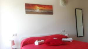 - un lit rouge avec 2 oreillers dans l'établissement B&B Villa Di Bartolomeo, à Capaccio-Paestum