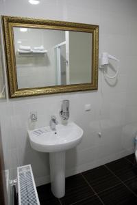 a bathroom with a white sink and a mirror at Міні-готель Пекін in Mykolaiv