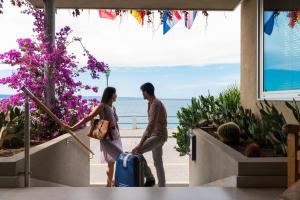a man and a woman walking with a suitcase at Hotel Miramare - Adults Only in Trieste