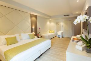 una camera con letto bianco e un soggiorno di Hotel Villa Garuti a Padenghe sul Garda