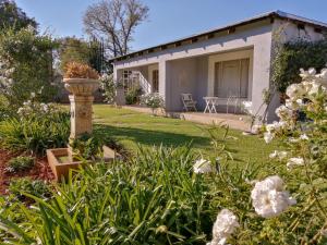 a house with a garden with flowers in the yard at Goedehoop Guesthouse in Zeerust