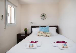 a bedroom with a white bed with flowers on it at Nahariya SEA VIEW, Ha-aliya in Nahariyya +57 photos