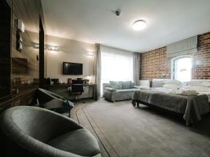 sypialnia z łóżkiem, krzesłem i kanapą w obiekcie Q Hotel Grand Cru Gdańsk w Gdańsku +37 zdjęć