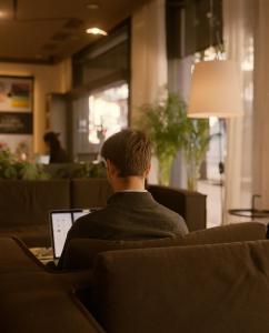 a man sitting in a chair with a laptop at Pol & Grace Hotel in Barcelona