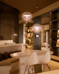 a restaurant with white chairs and a table and lights at Pol & Grace Hotel in Barcelona
