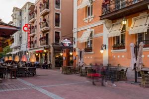 een stadsstraat met tafels, stoelen en gebouwen bij Villa Antica in Plovdiv