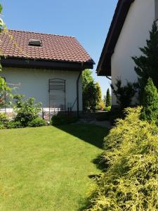 una casa con un patio de césped al lado de un edificio en Słoneczne Zacisze, en Wicko