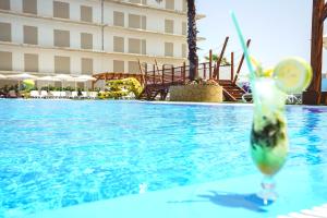 a drink with a lime slice in a glass in a swimming pool at AZ Hôtels Zephyr in Mostaganem