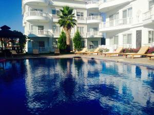 a swimming pool in front of a large building at BELKA GOLF RESİDENCE Dublex BELEK in Belek