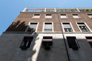 un edificio alto de ladrillo con ventanas y un cielo azul en Guest House Al Conservatorio, en Roma