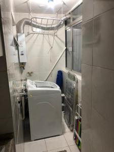 y baño pequeño con lavadora. en Apto aconchegante 100m Shopping Beiramar, en Florianópolis