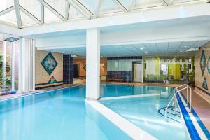 a large swimming pool with blue water in a building at Mercure St Helens in Saint Helens