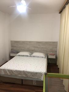 1 dormitorio con 1 cama y ventilador de techo en Apto aconchegante 100m Shopping Beiramar en Florianópolis