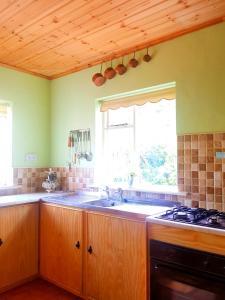 a kitchen with a sink and a window at Leenan View Country House in Portsalon
