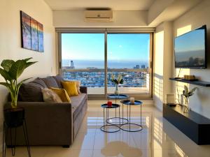 a living room with a couch and a large window at Topacio Tower apartamento de lujo in Buenos Aires