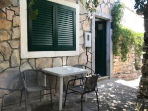 a table and chairs outside of a building with a window at Stone House Center in Primošten