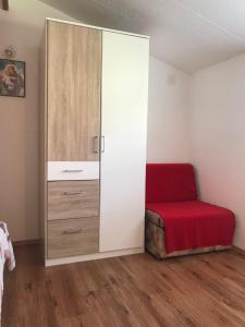 a room with a closet with a red bed and a cabinet at Stone House Center in Primošten