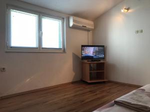an empty room with a television and a window at Stone House Center in Primošten