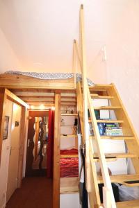 Cama elevada en habitación con escalera en Mon Mounier : Studio cosy au pied des pistes / Vue de rêve ! en Beuil