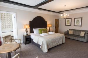 a bedroom with a bed and a table and a couch at Dukes Head Hotel in Kings Lynn