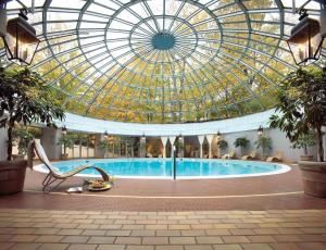een zwembad in een gebouw met een glazen plafond bij Toronto Don Valley Hotel and Suites in Toronto