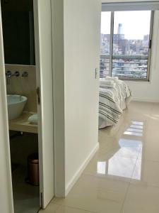 a white bathroom with a bed and a window at Topacio Tower apartamento de lujo in Buenos Aires
