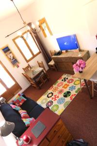 uma sala de estar com um sofá e uma mesa em Mon Mounier : Studio cosy au pied des pistes / Vue de rêve ! em Beuil