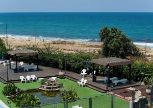a deck with chairs and a fountain and the beach at Ha-aliya Sea View in Nahariyya
