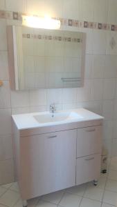 bagno con lavandino bianco e specchio di Giannos Apartments a Ayia Evfimia