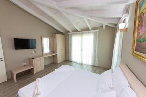 ヴロラにあるHotel Roiのベッド1台、テレビが備わる広い客室です。