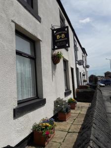 a sign on the side of a building with potted plants at Overnight Stays Stockport in Stockport