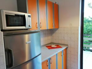 a kitchen with a stainless steel refrigerator and a microwave at Apartment Irena in Jadranovo