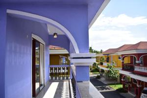 a blue building with an archway in a courtyard at Calvin's 3 BDR Villa in Benaulim
