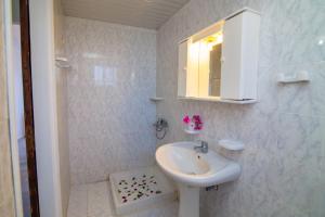 ein weißes Badezimmer mit einem Waschbecken und einem Spiegel in der Unterkunft Villa Doris in Laganas