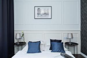 a bedroom with a white bed with blue pillows at Zwierzyńscy Residence 2 in Pobierowo