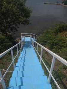 un puente con escaleras azules junto al agua en Blue Bay Palace Apart Complex, en Pomorie