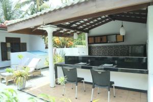a patio with a black counter and chairs under a pergola at Villa Koggala in Koggala