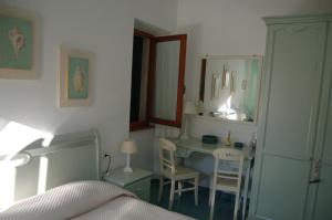 una camera da letto con scrivania, letto e specchio di La Rosada a Giglio Porto