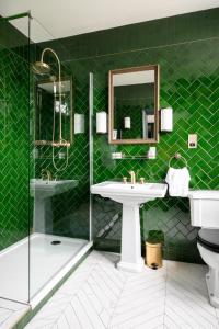 baño verde con lavabo y ducha en The Bedford Balham - Live Music Venue en Londres