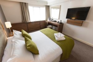 a hotel room with a bed and a flat screen tv at Dukes Head Hotel in King's Lynn