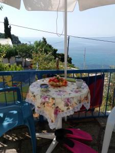 a table with a plate of fruit on a balcony at Stafylos Rooms in Stafylos
