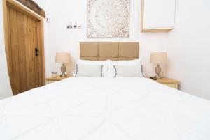 ein Schlafzimmer mit einem großen weißen Bett mit zwei Lampen in der Unterkunft The Nook Cottage in Carlisle