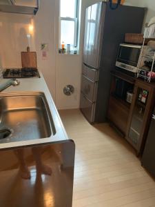 a kitchen with a stainless steel sink and a counter at Private room in new House in Tokyo