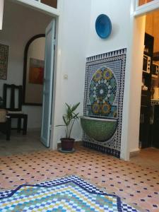 uma casa de banho com uma banheira em mosaico numa parede em Dar Mussarat em Essaouira