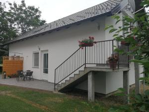 a white house with a staircase and a patio at New apartment near Plitvice lakes in Smoljanac